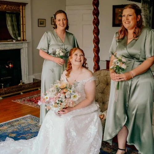 Bride-and-bridesmaids-laughing-together-in-the-Homme-House-main-suite