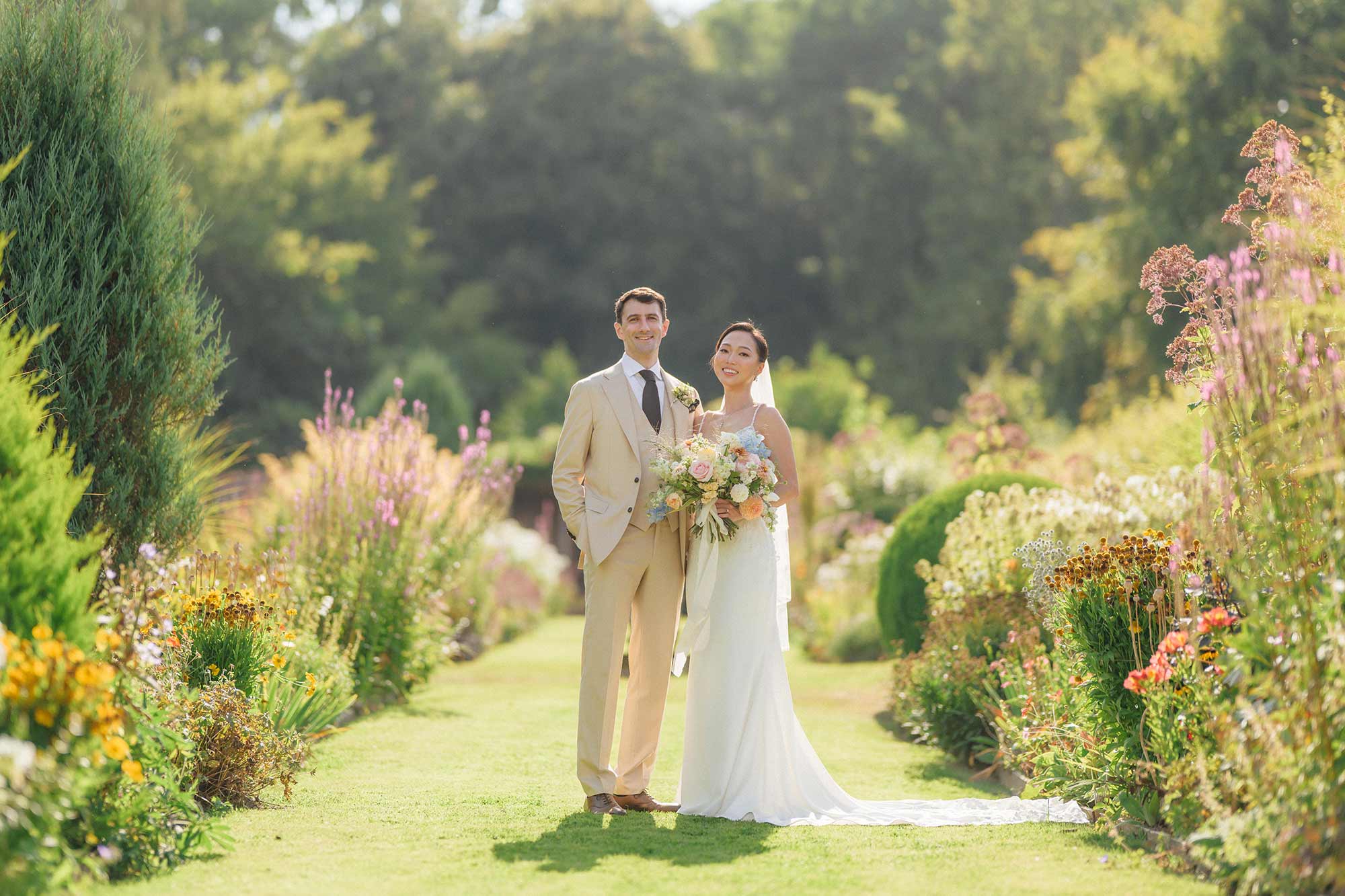 Bride-and-groom-standing-on-the-long-borders-at-Homme-House