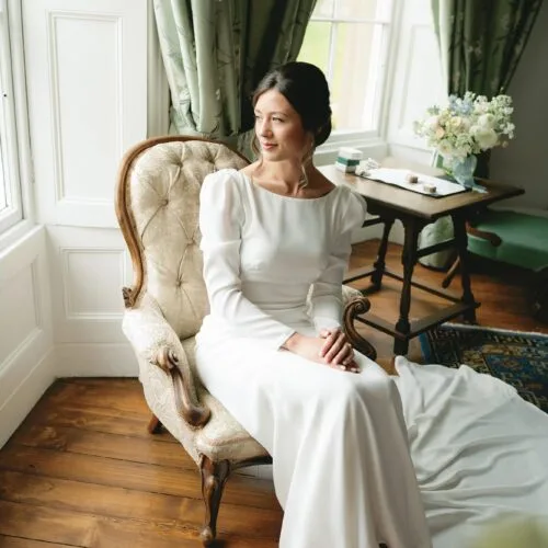 Bride-sits-in-bay-window-of-Homme-House-Main-Suite