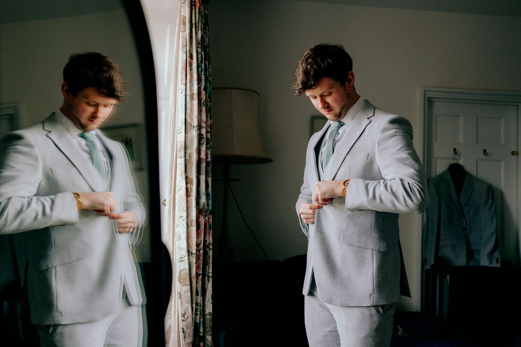 Groom-reflected-in-mirror-while-getting-ready-for-wedding-at-Homme-House