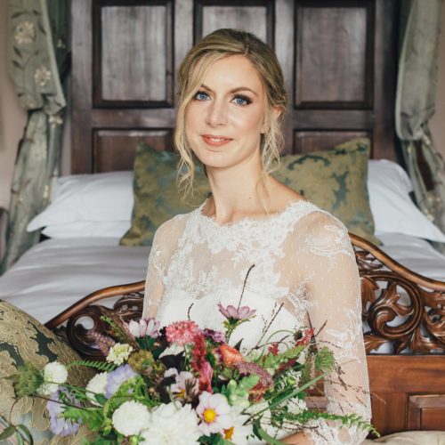 Bride sitting in front of Bridal Suite bed at Homme House