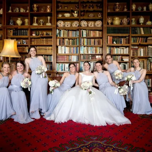 Bride and bridesmaids portrait on sofa in the Library at Homme House