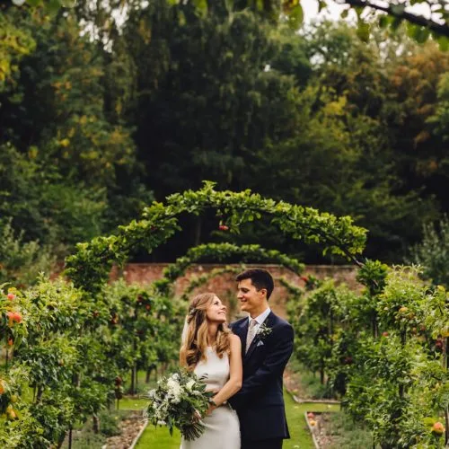 Bride and groom photograph under the espalier apples at Homme House