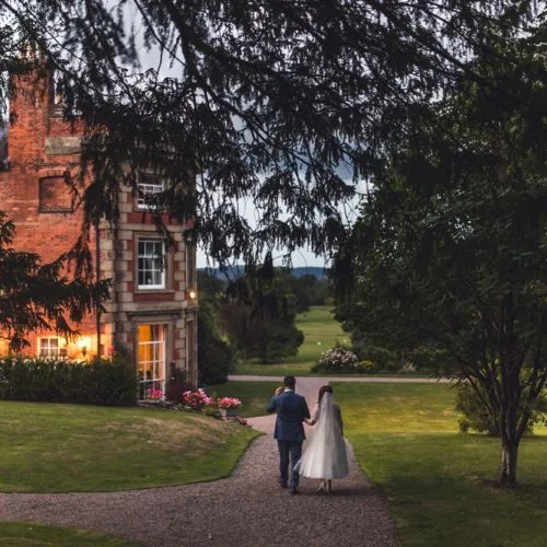 Bride and groom walking in Homme's garden in the evening