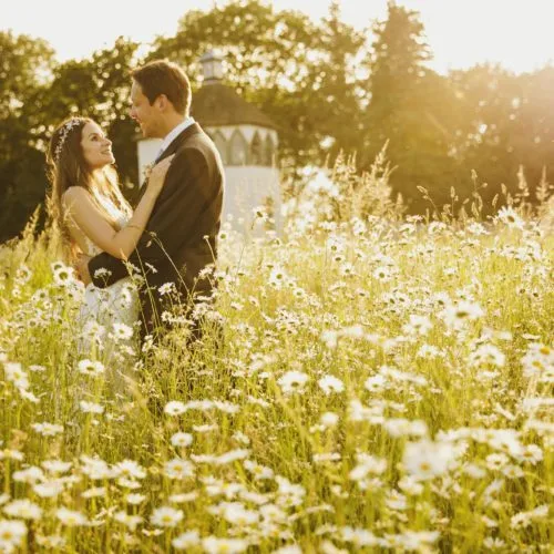 Bride and groom in Homme House wildflower meadow in evening light