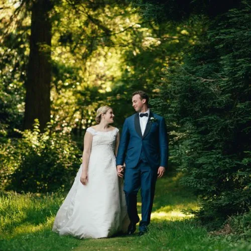 Bride and groom walking in woodland at Homme House