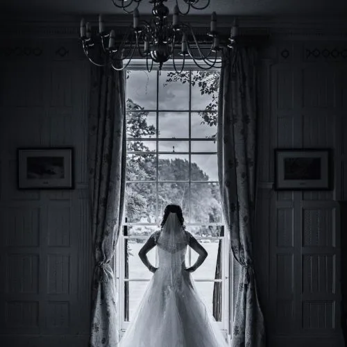 Bride portrait in front of the Georgian sash window in the Panelled Room at Homme House
