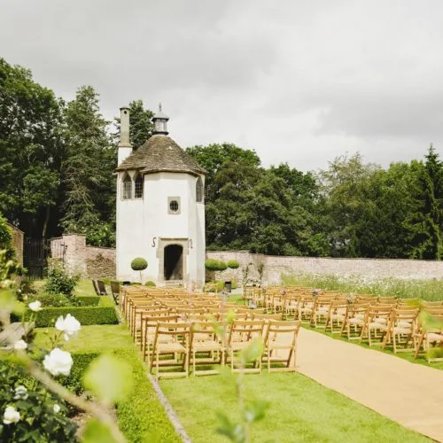 Seating laid out for outdoor walled garden ceremony outside Homme House's Summerhouse