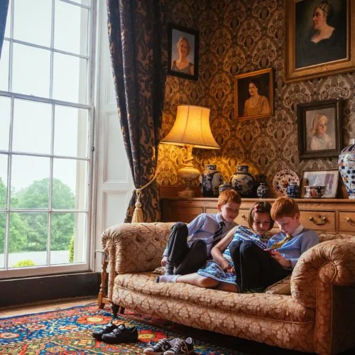 Children playing on a sofa in the Library at Homme House