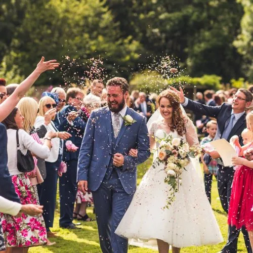 Wedding couple showered with confetti by guests in Walled Garden at Homme House