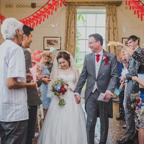 Wedding couple showered with confetti by guests in Homme House's Panelled Room