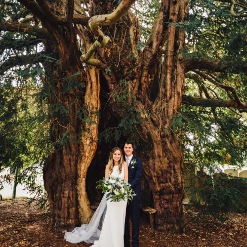 Couple portrait in front of yew tree at St. Bartholomew's Church, Much Marcle