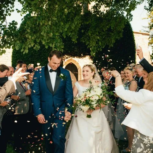 Couple showered with confetti following wedding service at St. Bartholomew's Church, Much Marcle