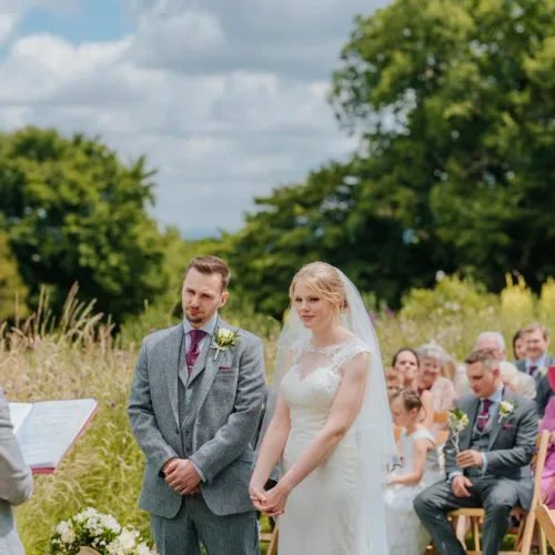 Couple exchanging vows during outdoor wedding ceremony at Homme House