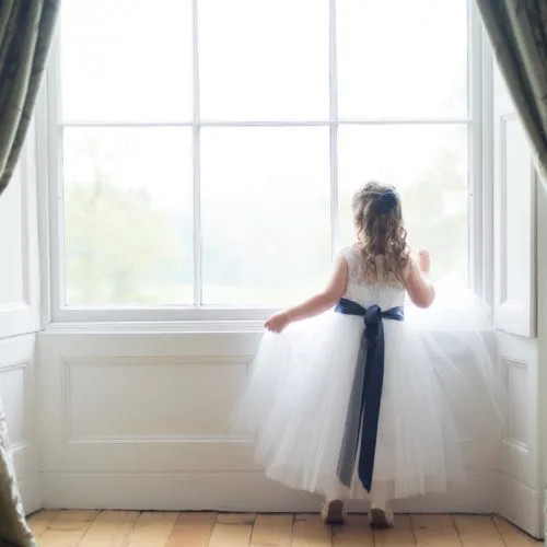 Flowergirl looking out of the Bridal Suite window at Homme House