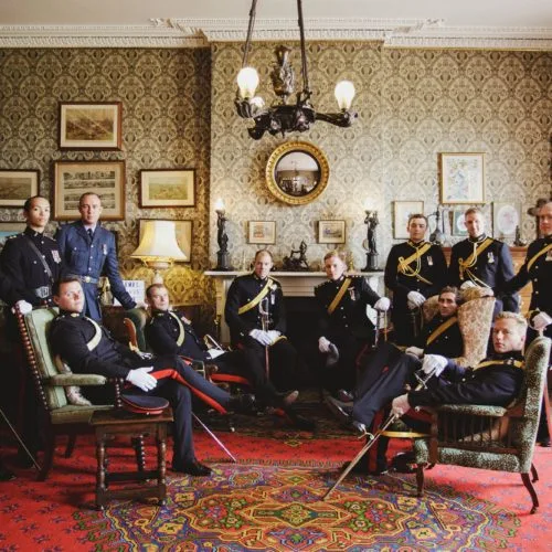 Groom and groomsmen portrait in military dress in the Library at Homme House