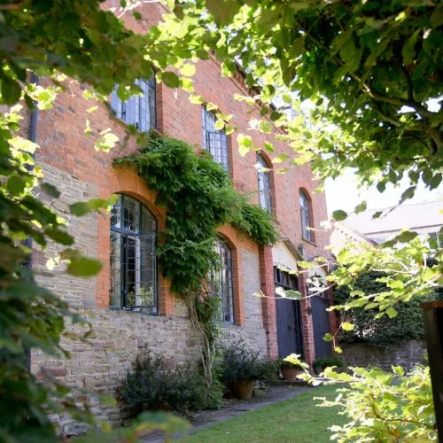 The Coach House at Homme House through beech arch gateway