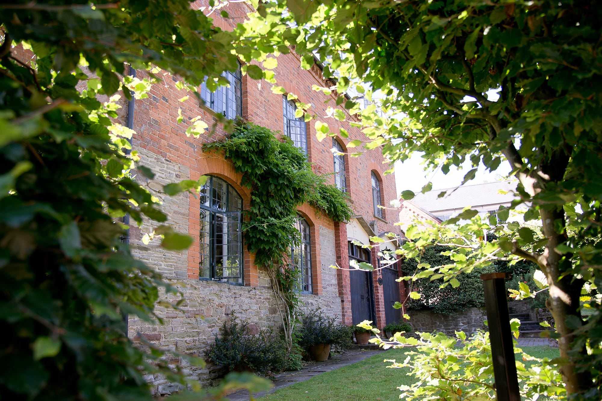 The Coach House at Homme House through beech arch gateway