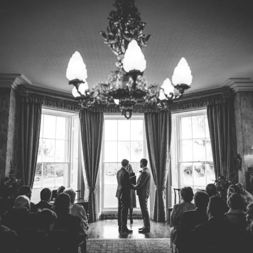Same sex couple exchanging vows during wedding ceremony