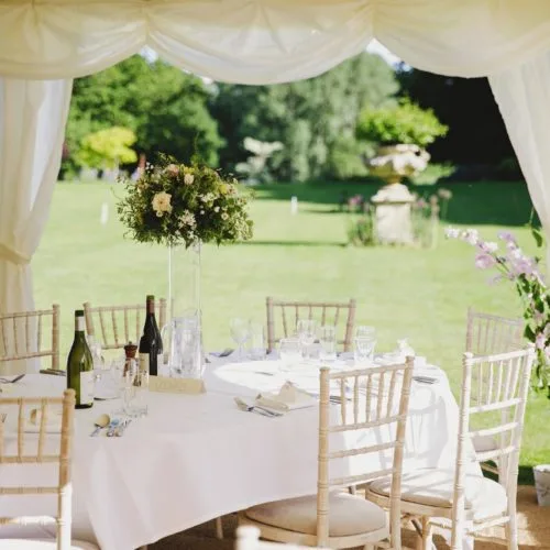 Table laid up for wedding breakfast in marquee on the lawn at Homme House