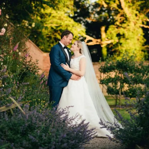 Wedding couple photograph in front of the borders of the walled garden at Homme House