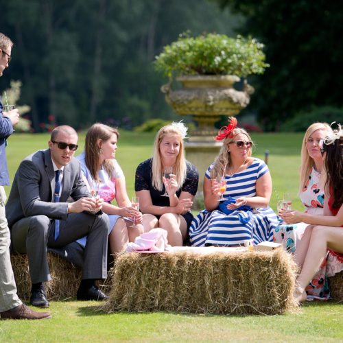 Wedding guests and hay bale seating on the main lawn at Homme House