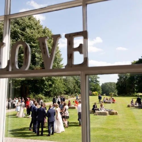 Wedding guests and hay bale seating on the main lawn at Homme House
