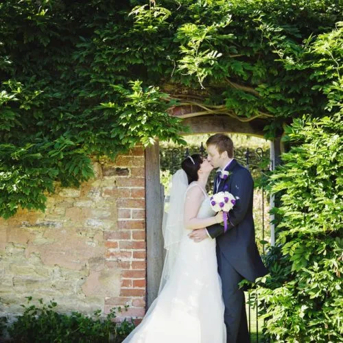Wedding couple portrait beside wisteria