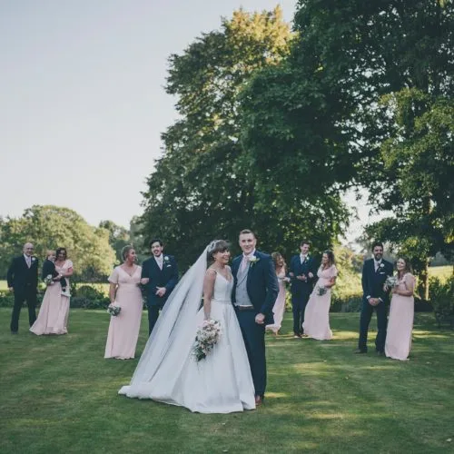 Bride, groom and the Bridal party assembled for a group photograph on the lawn at Homme House