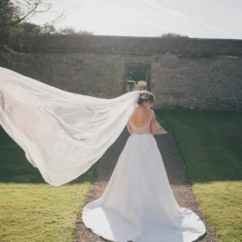 A bride\'s veil floats in the breeze in the garden at Homme House