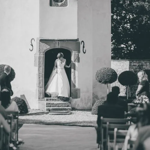 Bride emerging from Summerhouse during wedding ceremony