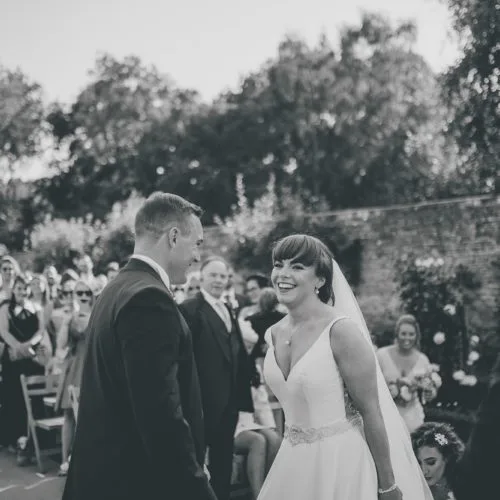 Bride and groom laughing during a Walled Garden ceremony at Homme House