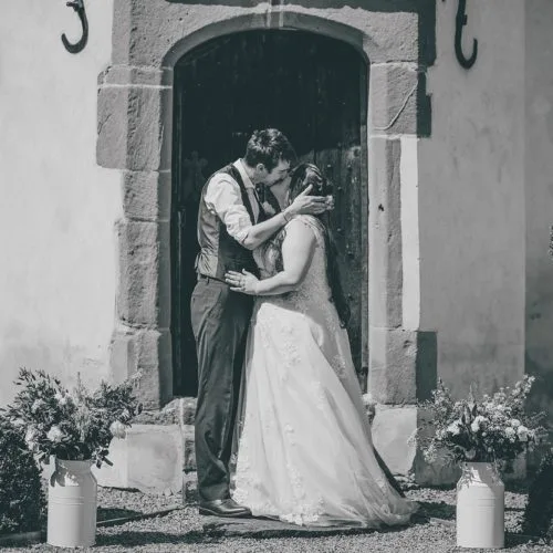 A bride and groom kiss outside the Summerhouse at Homme House