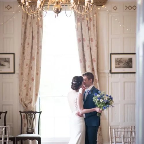 A wedding couple kiss in the Panelled Room at Homme House