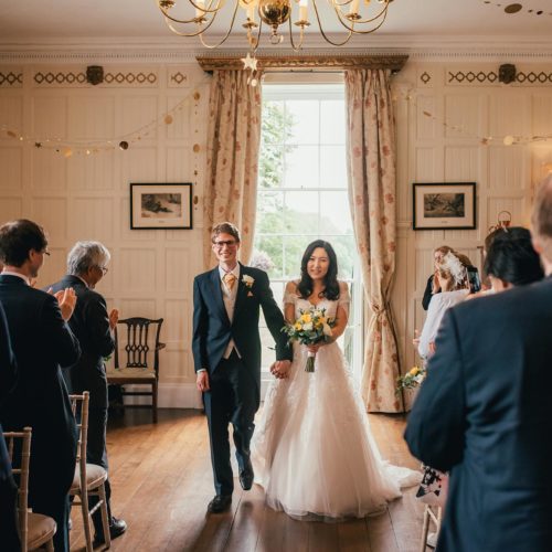 A bride and groom leave the Panelled Room at the end of a wedding ceremony