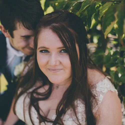 Bride and groom sitting under a cornus in the rose garden at Homme House