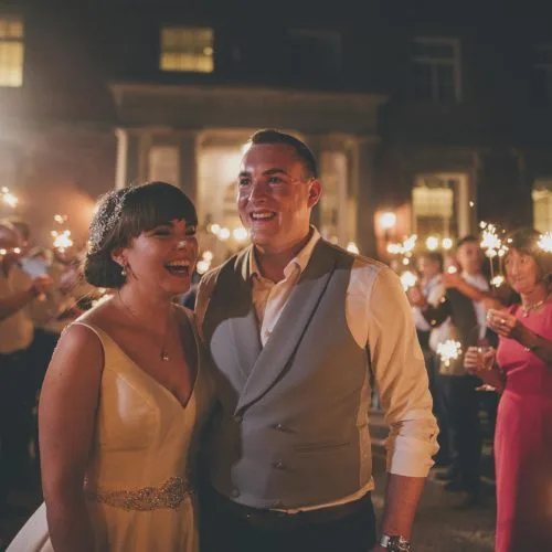 Bride and groom and guests with sparklers outside Homme House