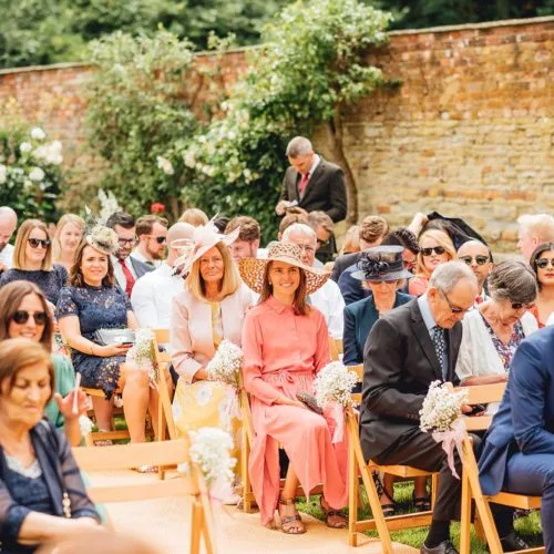 Guests awaiting the start of a walled garden wedding ceremony