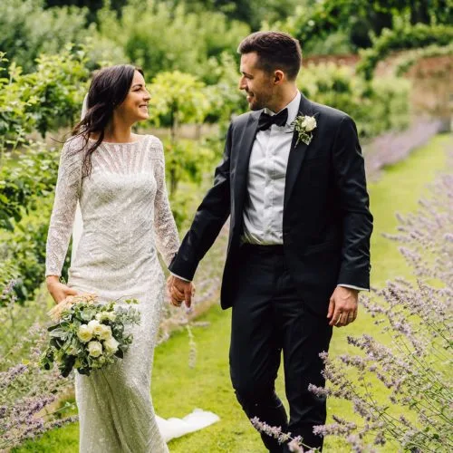 A wedding couple on the espalier walk in Homme House\'s walled garden