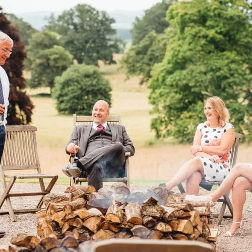 Guests relax in front of fire bowls outside Homme House