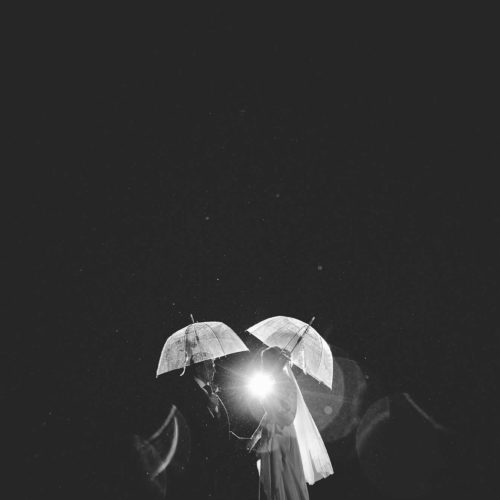 An evening portrait of bride and groom in the rain