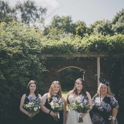 Bridal-party-in-front-of-wisteria-covered-gateway