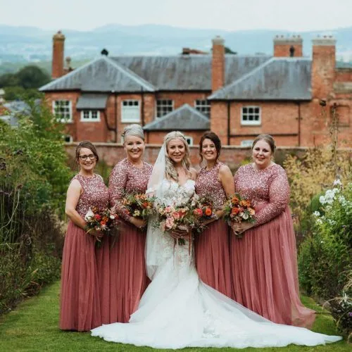 Bride-and-bridesmaids-portrait-beside-long-flower-borders