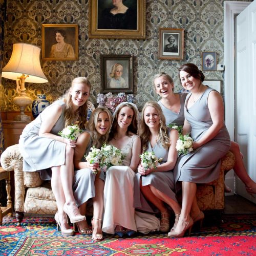 Bride-and-bridesmaids-portrait-on-Homme-House-Library-sofa