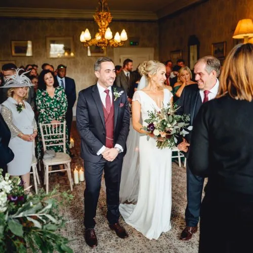 Bride-and-groom-at-start-of-indoor-wedding-ceremony-at-Homme-House-in-front-of-congregation