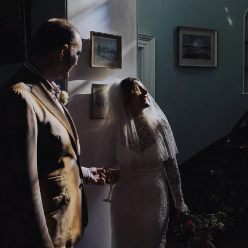 Bride-and-groom-in-sunlit-Hall
