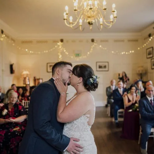 Bride-and-groom-kiss-in-Homme-House-Panelled-Room-wedding-ceremony