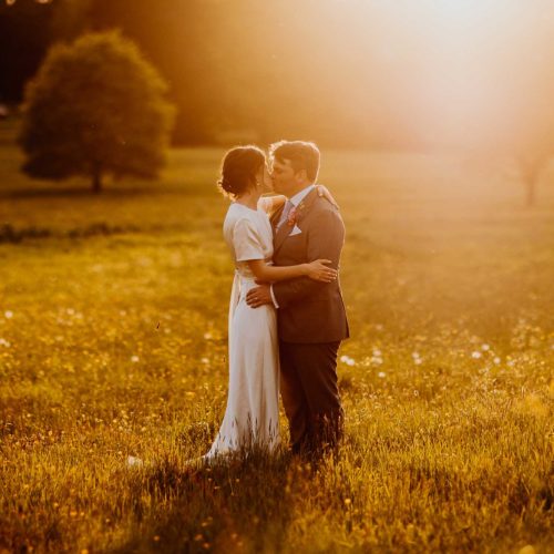 Bride-and-groom-kiss-in-Homme-House-parkland-evening-sunshine