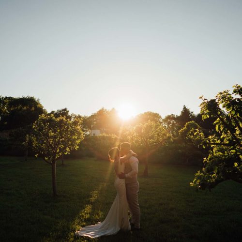 Bride-and-groom-kiss-in-Homme-House-walled-garden-evening-sunshine