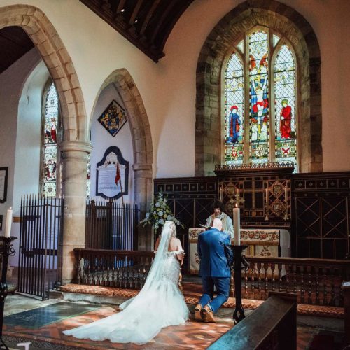 Bride-and-groom-kneel-at-the-altar-in-church